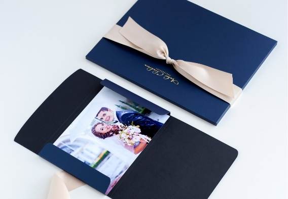 Navy blue professional photo and portrait cases with ribbon tie closure holding client print packages