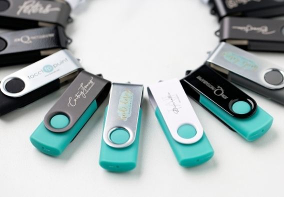 Custom engraved USB flash drives in black and teal with studio branding for digital photo delivery