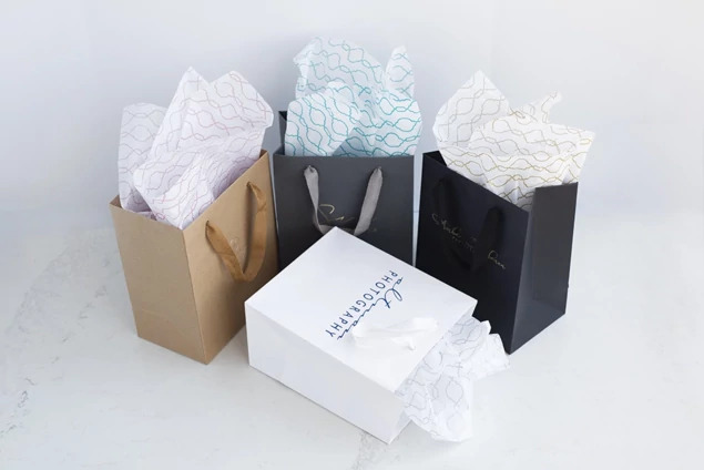 Black Euro Tote bags shown alongside white and kraft tote bags comparing boutique packaging options
