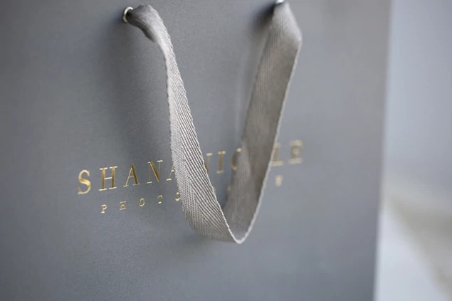 Close-up of slate gray Euro Tote bag showing foil imprinted studio branding on front panel