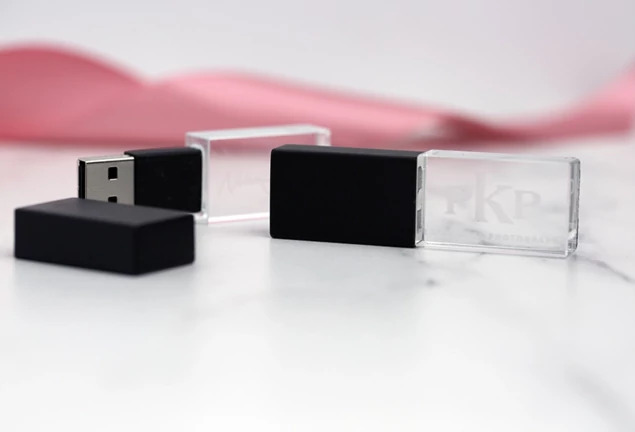 Black cap crystal flash drive shown against pink background highlighting clear crystal body design