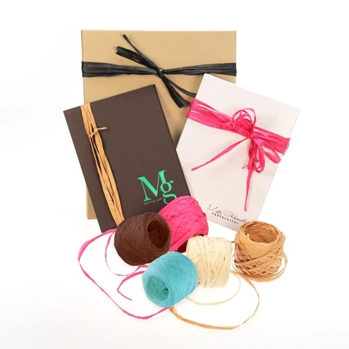 Tyndell Raffia in Fuchsia, Chocolate, Kraft, Cream, Turquoise, and Black showing 52-yard rolls for photo packaging accessory