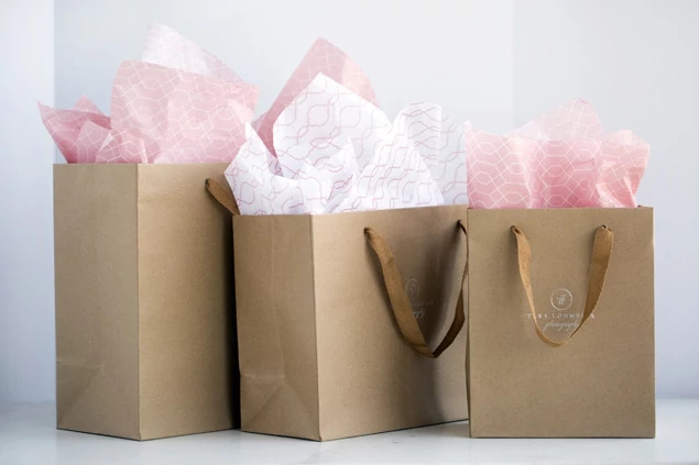 Two kraft Euro Tote bags in different sizes shown with pink tissue paper and cotton twill handles