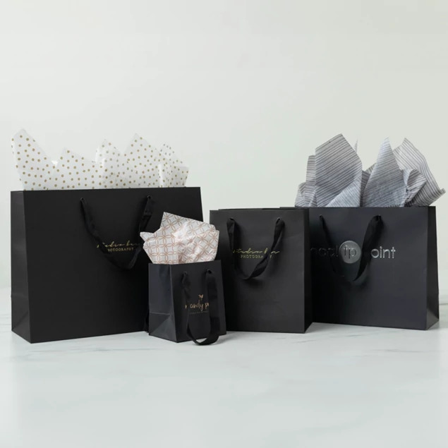 Black Euro Tote bags in three sizes shown together with tissue paper and a small gift box