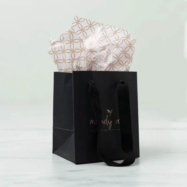 Small black Euro Tote bag with tissue paper showing foil imprinted studio logo detail