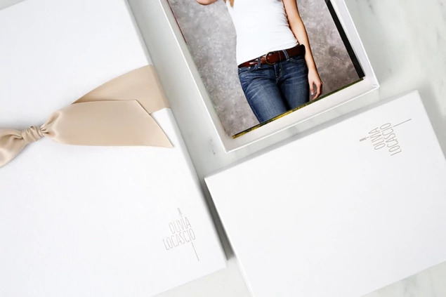 White leather portrait box open with portrait print and silver foil studio logo     Tyndell portrait packaging