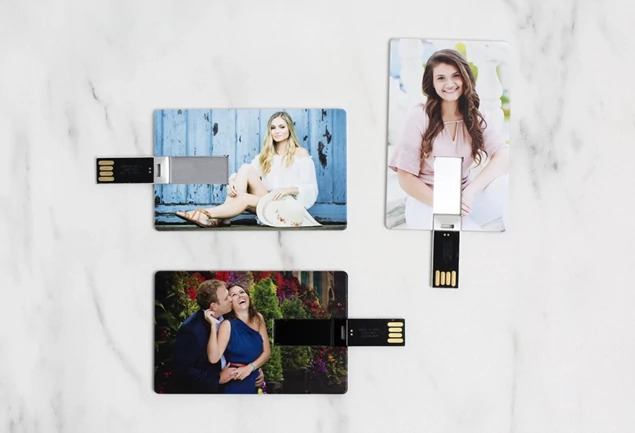 Close-up of silver metallic credit card flash drive showing full-color custom printed surface