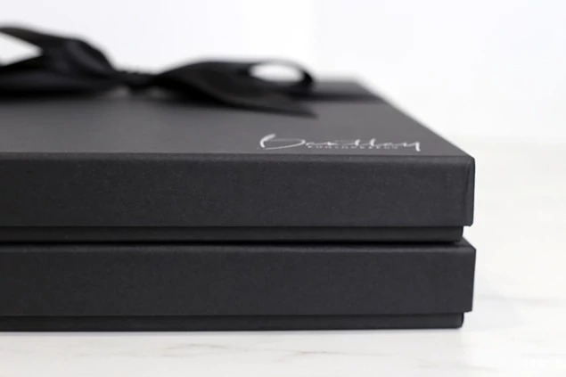 Square Photo Book Box with foil imprinted studio logo and ribbon accessory for high-end presentation