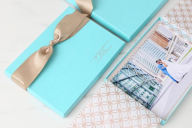 Open robin egg blue deluxe portrait box with champagne ribbon and portrait prints inside     Tyndell portrait packaging