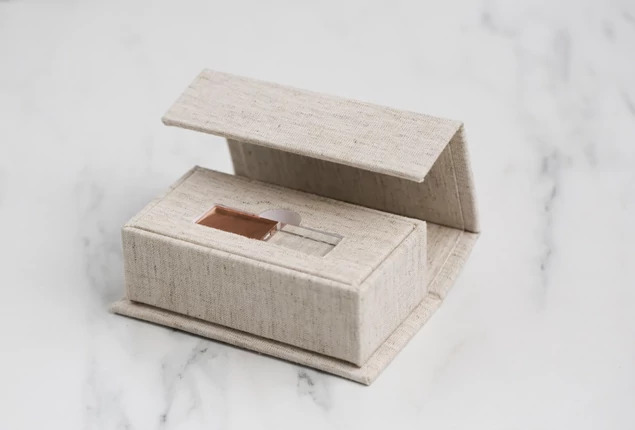 Linen Luxe Fabric USB Box closed showing clean linen fabric exterior with engraved studio branding on lid