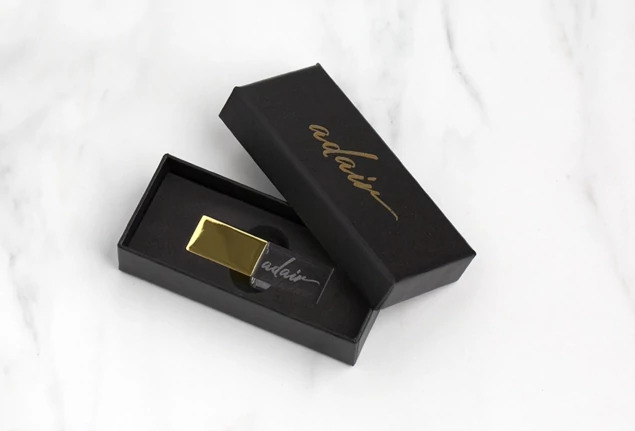 Gold cap crystal flash drive inside open black rigid USB Gift Box showing foam insert and gift presentation
