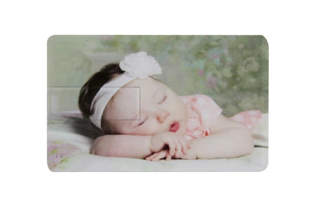 Close-up of white credit card flash drive with full-color newborn photo printed on front