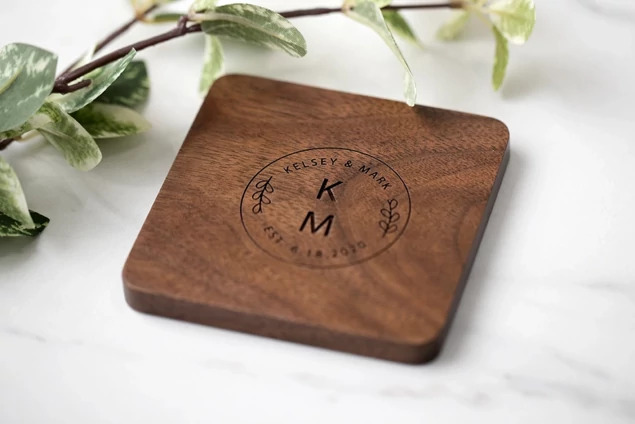 Tyndell Walnut Wood Coaster Set of 4 showing laser engraved studio logo on natural walnut wood surface