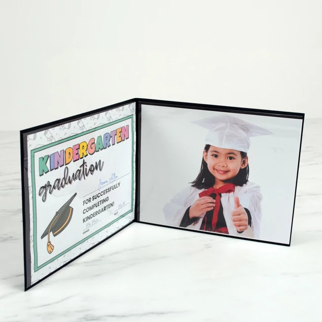Black Grad Folder open displaying graduation portrait and certificate in plastic sleeves