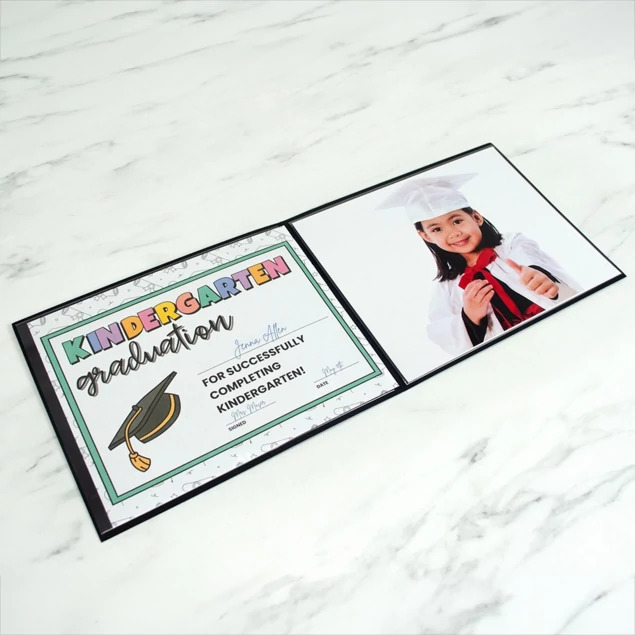 Black Grad Folder open with graduation portrait photos showing clean edge design and foil border