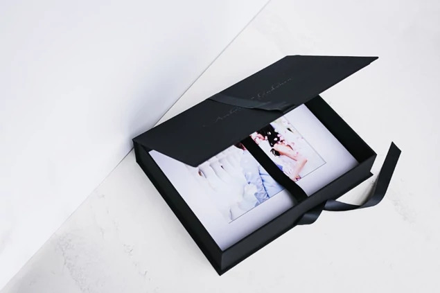 Archival portfolio mats inside open black portfolio box with ribbon     Tyndell portrait mat packaging