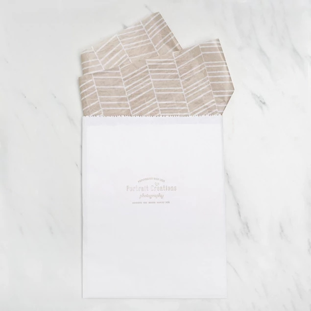 White flat paper merchandise bags in multiple sizes shown together for studio photo delivery