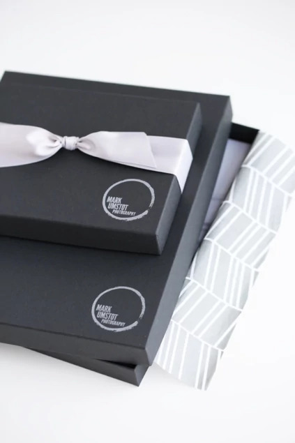 Close-up of matte black portrait box corner with custom foil imprinted studio logo     Tyndell portrait packaging
