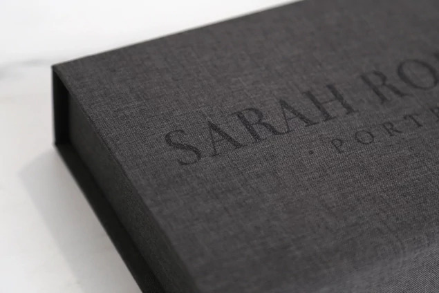 Close-up of carbon fabric flash and print box lid with laser engraved studio name