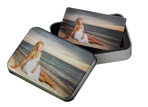 Multiple white credit card flash drives with custom photo printing shown with metal flash drive tin