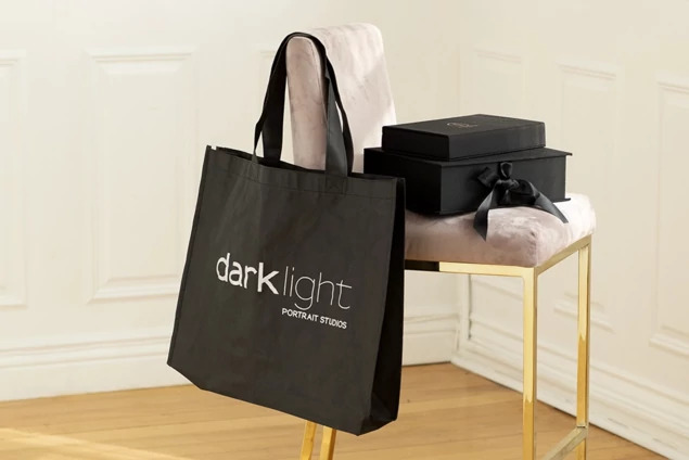 Black frame bag close-up showing nonwoven fabric construction and reinforced shoulder handles